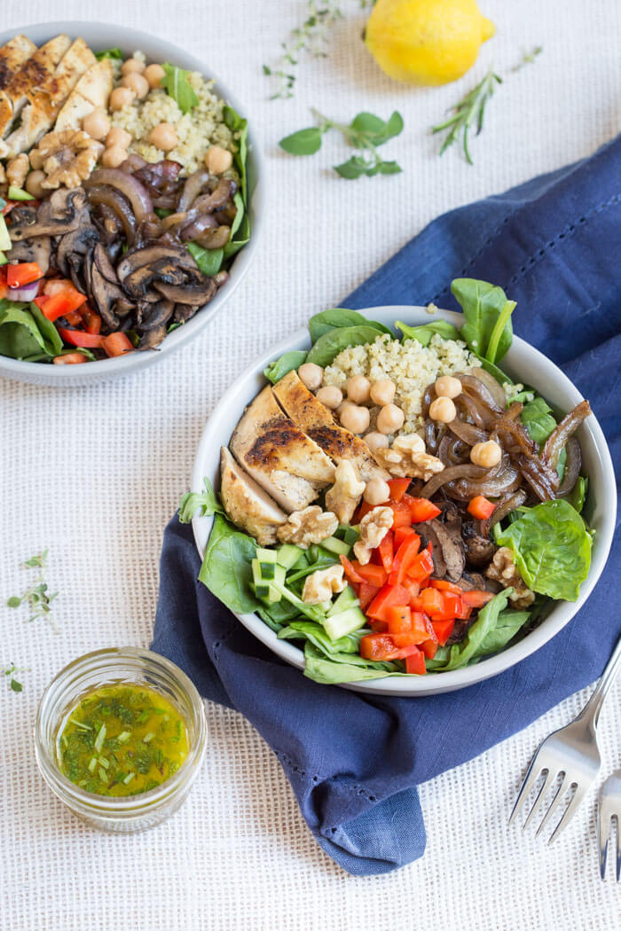 The perfect summer salad has grilled ingredients served warm served with fresh raw veggies. This Mediterranean Quinoa Chicken Salad bowl is topped with grilled chicken, sautéed onions and mushrooms and a zesty herb dressing.