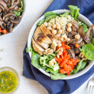 bowl is topped with grilled chicken, sautéed onions and mushrooms and a zesty herb dressing.
