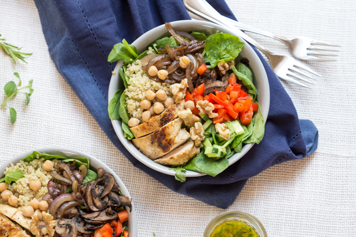 The perfect summer salad has grilled ingredients served warm served with fresh raw veggies. This Mediterranean Quinoa Chicken Salad bowl is topped with grilled chicken, sautéed onions and mushrooms and a zesty herb dressing.