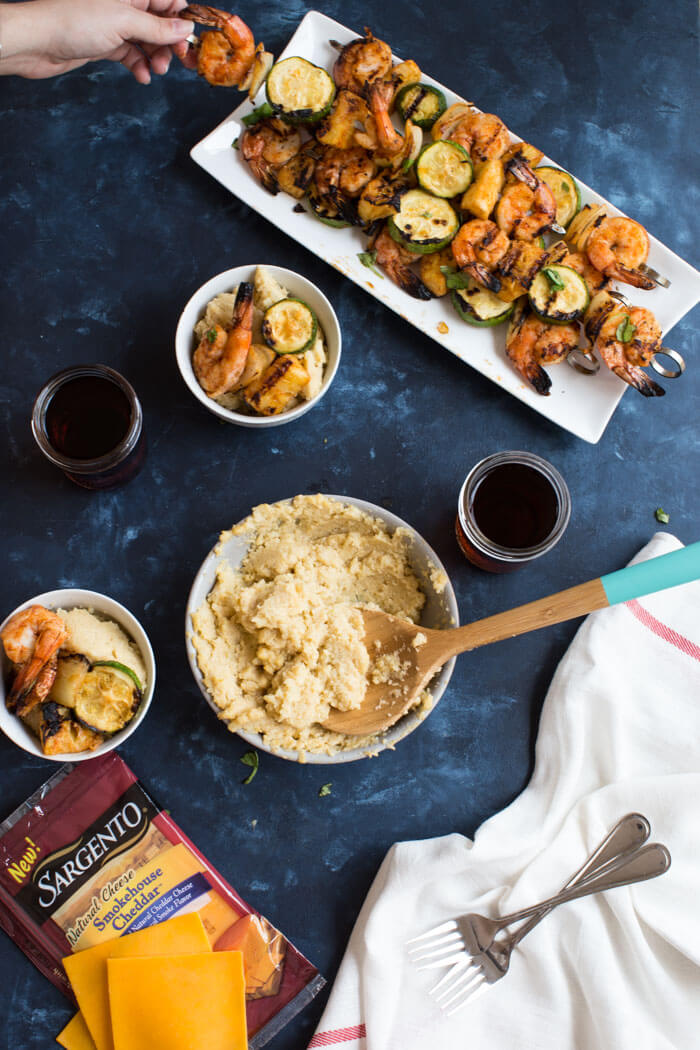 A classic southern dish gets a smoky twist with these Smoky Cheddar Cauliflower Grits and Cajun Shrimp. Cheesy cauliflower grits are served alongside sweet and spicy shrimp skewers with zucchini and pineapple.