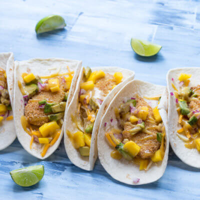 Honey Mustard Fish Tacos made with wild caught pollock tenders, onion, mango, avocado, and cheese nestled in a tortilla and drizzled with honey mustard! A tasty dinner on the table in less than 20 minutes.