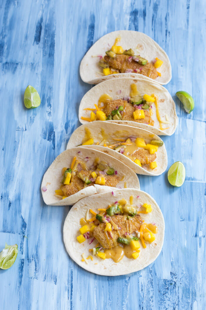 Honey Mustard Fish Tacos made with wild caught pollock tenders, onion, mango, avocado, and cheese nestled in a tortilla and drizzled with honey mustard! A tasty dinner on the table in less than 20 minutes.