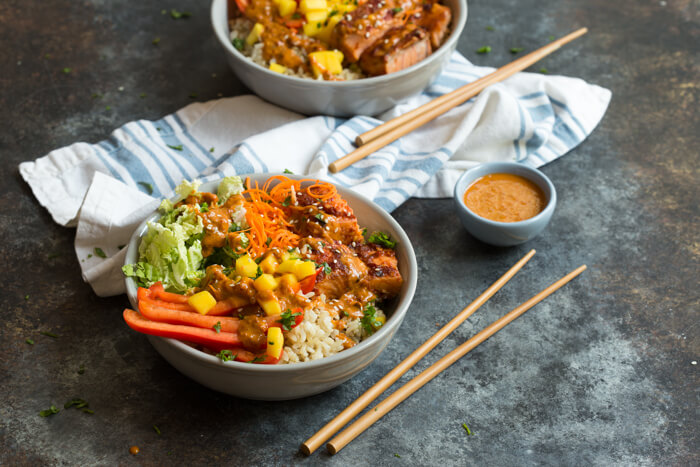 Spicy Thai Salmon Grain Bowls loaded with veggies, brown basmati rice and warm baked salmon and a drizzle of spicy Thai sauce.... because everything is better in bowl form.