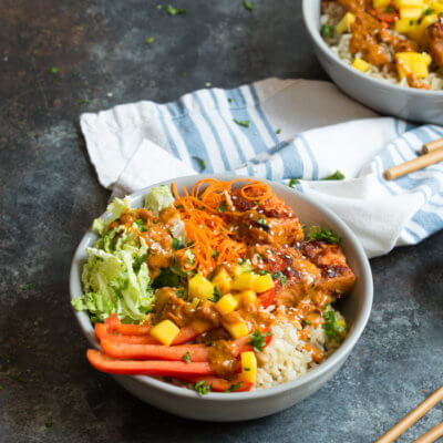 Spicy Thai Salmon Grain Bowls loaded with veggies, brown basmati rice and warm baked salmon and a drizzle of spicy Thai sauce.... because everything is better in bowl form.