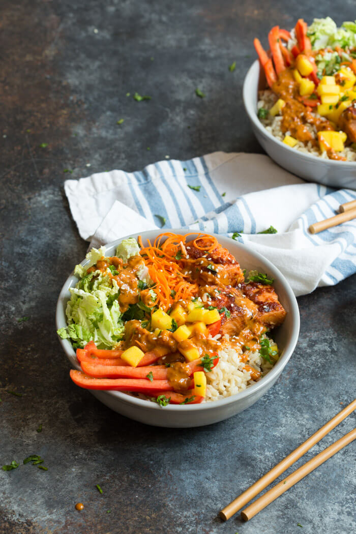 Spicy Thai Salmon Grain Bowls loaded with veggies, brown basmati rice and warm baked salmon and a drizzle of spicy Thai sauce.... because everything is better in bowl form.