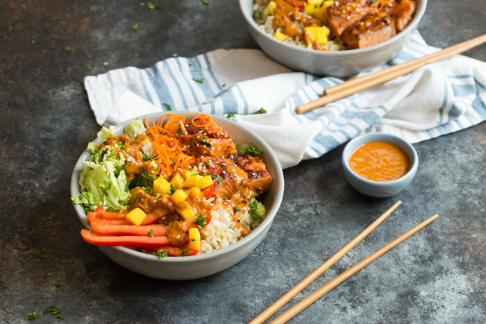 Spicy Thai Salmon Grain Bowls loaded with veggies, brown basmati rice and warm baked salmon and a drizzle of spicy Thai sauce.... because everything is better in bowl form.