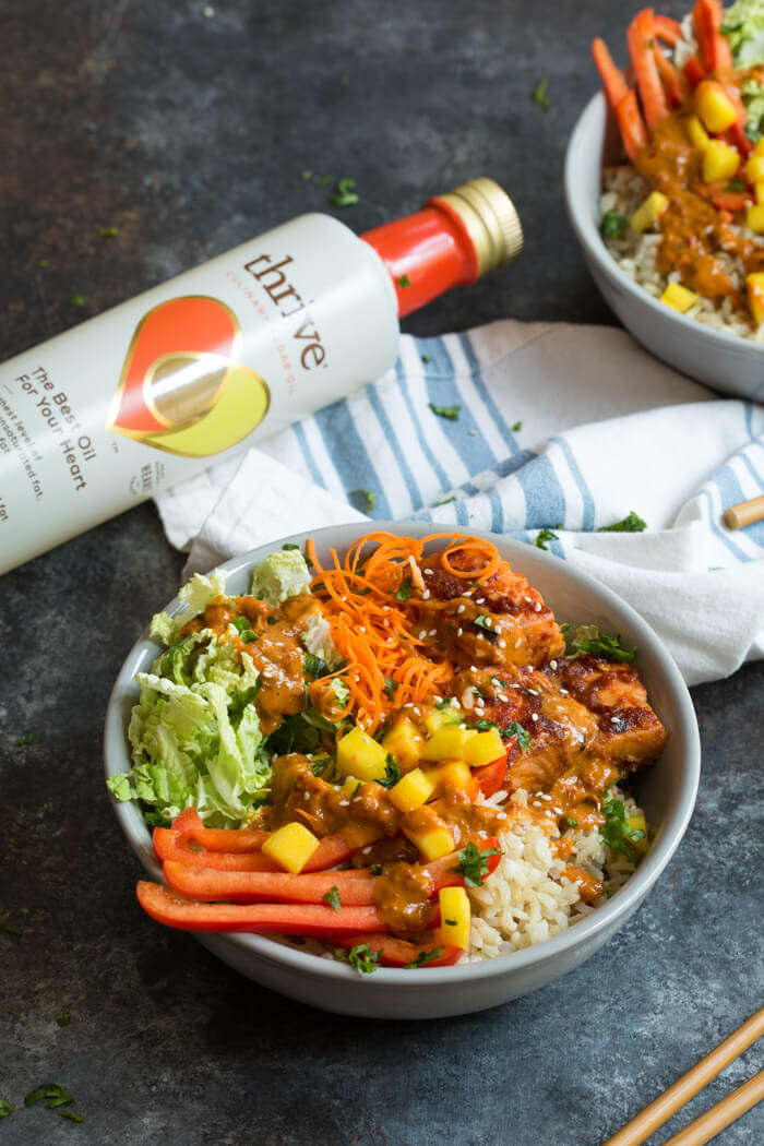 Spicy Thai Salmon Grain Bowls loaded with veggies, brown basmati rice and warm baked salmon and a drizzle of spicy Thai sauce.... because everything is better in bowl form.