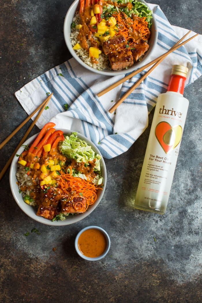 Spicy Thai Salmon Grain Bowls loaded with veggies, brown basmati rice and warm baked salmon and a drizzle of spicy Thai sauce.... because everything is better in bowl form.