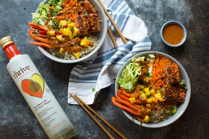 Spicy Thai Salmon Grain Bowls loaded with veggies, brown basmati rice and warm baked salmon and a drizzle of spicy Thai sauce.... because everything is better in bowl form.