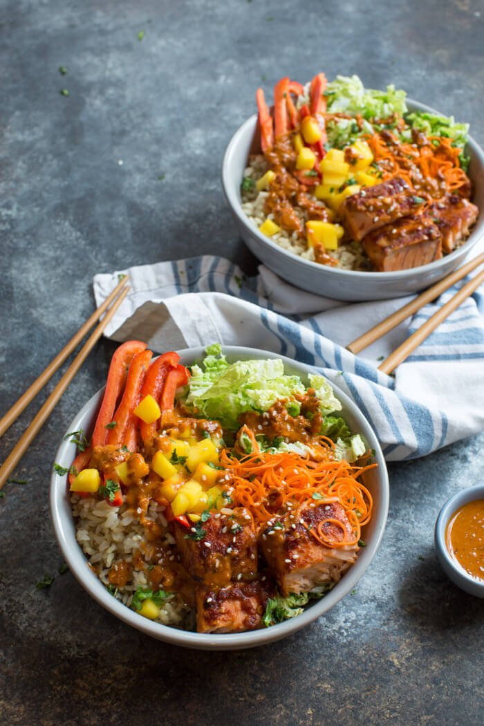 Spicy Thai Salmon Grain Bowls loaded with veggies, brown basmati rice and warm baked salmon and a drizzle of spicy Thai sauce.... because everything is better in bowl form.