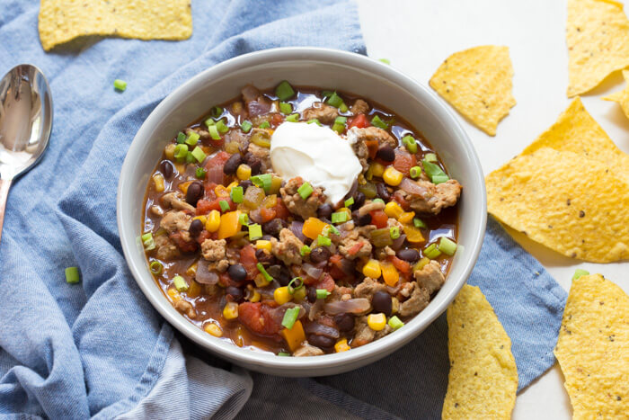 overhead shot of turkey taco soup topped with sour cream 
