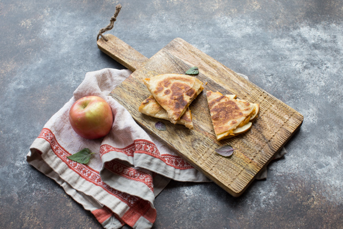 If you're looking for a simple comfort food dinner (or lunch) that tastes like fall-- this is it! Creamy Pumpkin Apple Quesadillas are perfect for little hands for snacking after school or before trick or treating. 