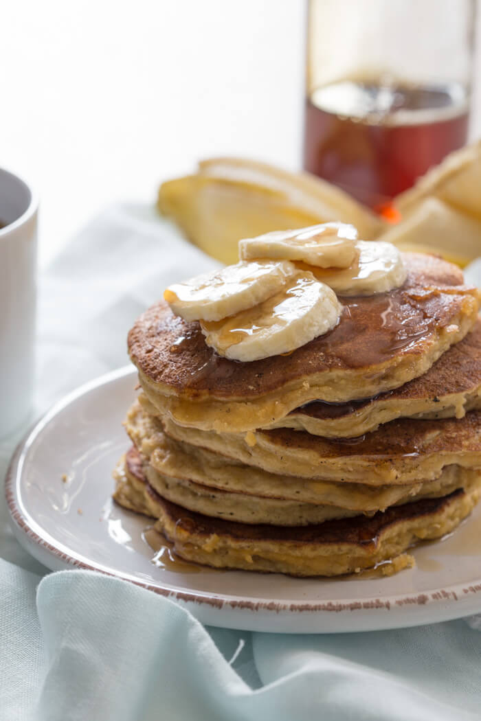 close up shot of paleo banana coconut flour pancakes with maple syrup