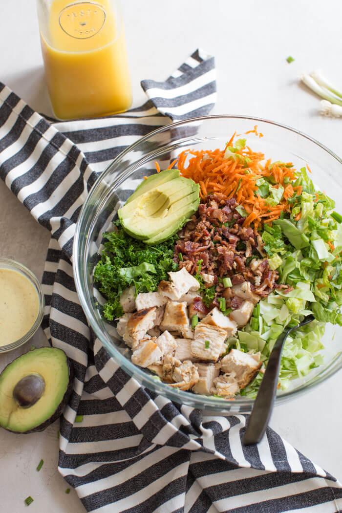 OH ME OH MY! This Farmhouse Chicken Chopped Salad with romaine, cabbage, kale, carrots, grilled chicken breast, bacon, sunflower seeds and avocado tossed in a tangy orange honey mustard dressing is my jam.