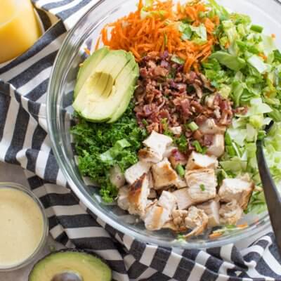 OH ME OH MY! This Farmhouse Chicken Chopped Salad with romaine, cabbage, kale, carrots, grilled chicken breast, bacon, sunflower seeds and avocado tossed in a tangy orange honey mustard dressing is my jam.