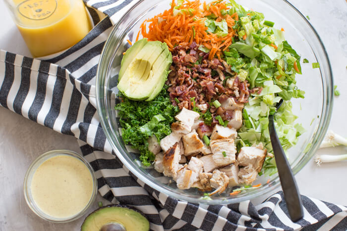 OH ME OH MY! This Farmhouse Chicken Chopped Salad with romaine, cabbage, kale, carrots, grilled chicken breast, bacon, sunflower seeds and avocado tossed in a tangy orange honey mustard dressing is my jam.