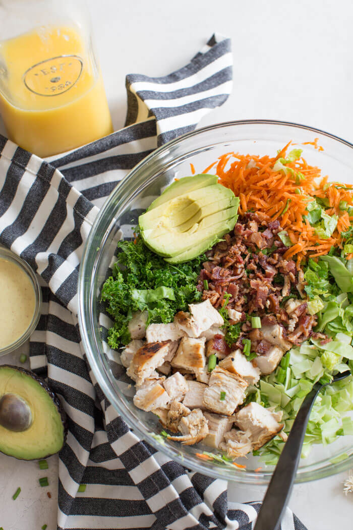 OH ME OH MY! This Farmhouse Chicken Chopped Salad with romaine, cabbage, kale, carrots, grilled chicken breast, bacon, sunflower seeds and avocado tossed in a tangy orange honey mustard dressing is my jam.