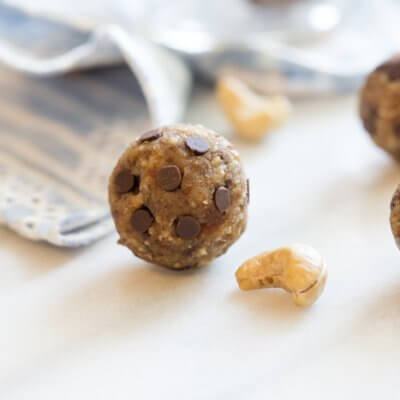 Irresistible Grain Free Chocolate Chip Cookie Dough Balls. These are super moist and taste like chocolate chip cookie dough...but they are grain free, egg free, dairy free-- that's no butter ya'll. Don't get me wrong, I love a good buttery chocolate chip cookie, but I do think there is room for healthier versions of the good stuff too, especially if you're looking for more wholesome snacks, breakfasts or desserts. These chocolate chip cookie dough balls are made with a few whole food ingredients-- cashews, dates, and flaxseed + chocolate, duh.  The secrete for soft and irresistible chocolate chip cookie dough balls of goodness? Soak cashews in dates in almond milk before blending.  For this recipe a large food processor is necessary to get the cashews and dates chopped small enough.  Irresistible Grain Free Chocolate Chip Cookie Dough Balls Author: Kristina LaRue Prep time: 15 mins Total time: 15 mins Serves: 32 balls Irresistible Grain Free Chocolate Chip Cookie Dough Balls. These chocolate chip cookie dough balls are made with a few whole food ingredients-- cashews, dates, and flaxseed + chocolate, duh. Grain free, egg free, dairy free-- that's no butter ya'll. Ingredients 8 pitted medjool dates 1 cup raw cashews 1/2 cup unsweetened vanilla almond milk 1/2 cup ground flaxseed pinch of large crystal salt 1 teaspoon vanilla extract 1/4 cup coconut flour 1/2- 3/4 cup semi-sweet mini chocolate chips Instructions In small bowl, soak dates and cashews in almond milk for at least an hour. In bowl of food processor, pour soaked dates, cashews, and any remaining almond milk; process until dates and cashews are minced. Add flaxseed, salt, and vanilla extract and pulse until blended. Remove blade and stir in coconut flour until mixed and then mix in chocolate chips. Place parchment paper on clean surface. Coat hands in coconut oil or cooking spray and form dough into 32 small bite sized balls. Store balls in airtight container in fridge.