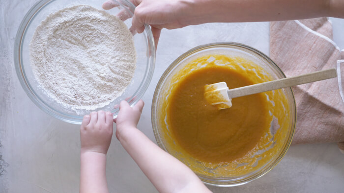 toddler hands helping mom make pumpkin muffins