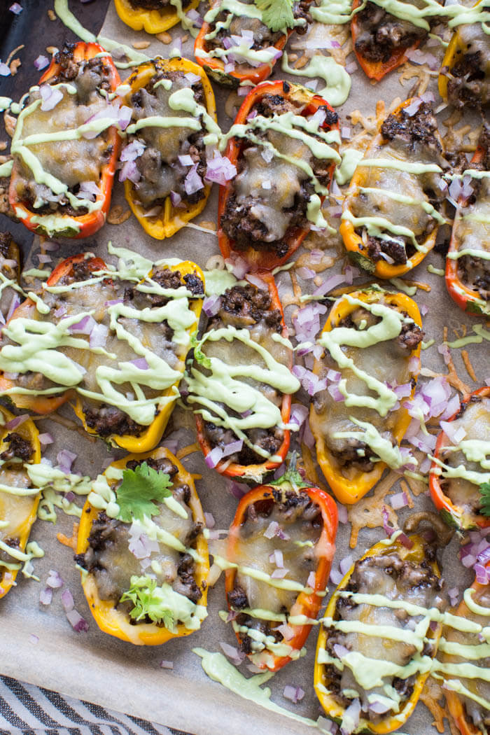 Mini Bell Pepper Nachos with Avocado Cream made on a sheet pan. These plant based mushroom loaded nachos with cool avocado cream are a veggie lovers dream. 