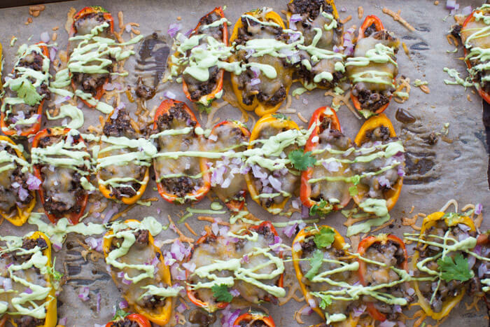 Mini Bell Pepper Nachos with Avocado Cream made on a sheet pan. These plant based mushroom loaded nachos with cool avocado cream are a veggie lovers dream. 