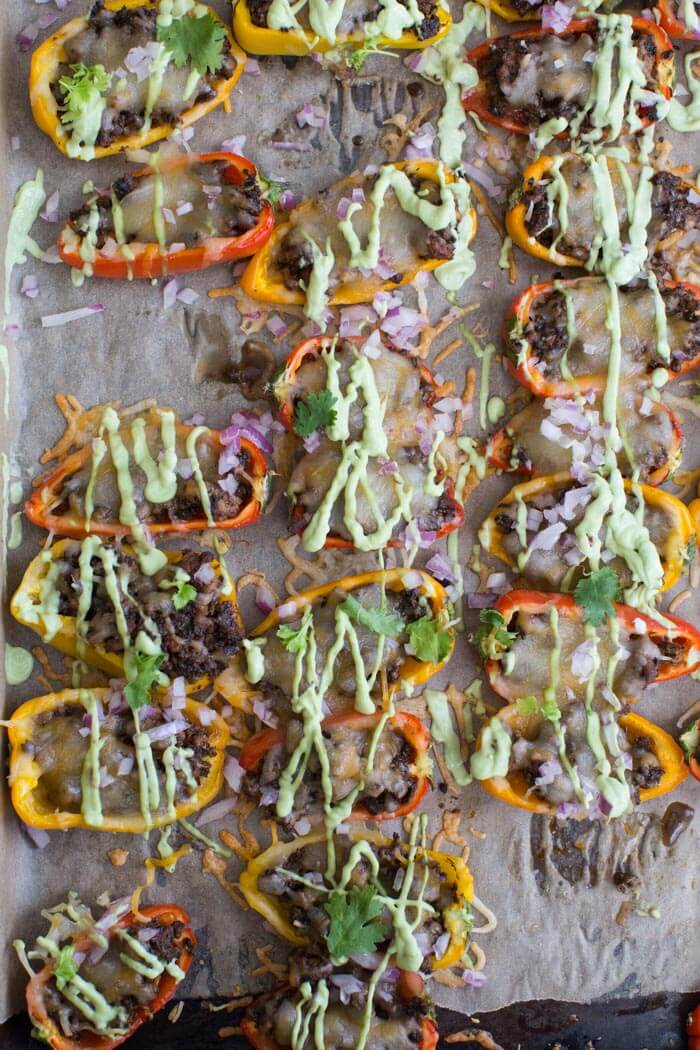 Mini Bell Pepper Nachos with Avocado Cream made on a sheet pan. These plant based mushroom loaded nachos with cool avocado cream are a veggie lovers dream. 