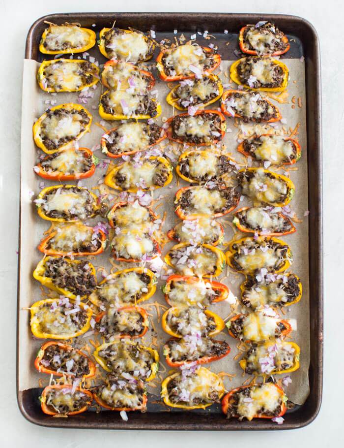 Mini Bell Pepper Nachos with Avocado Cream made on a sheet pan. These plant based mushroom loaded nachos with cool avocado cream are a veggie lovers dream. 