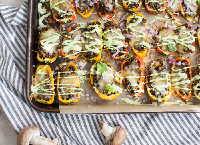 Mini Bell Pepper Nachos with Avocado Cream made on a sheet pan. These plant based mushroom loaded nachos with cool avocado cream are a veggie lovers dream. 