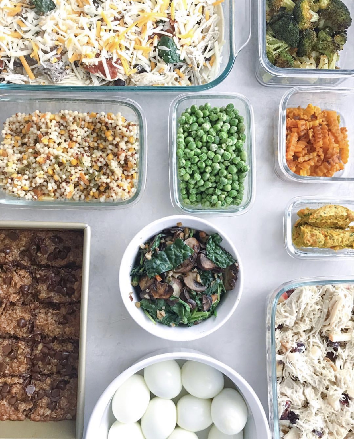 overhead shot of healthy meal prep with casserole, bars, eggs, chicken salad