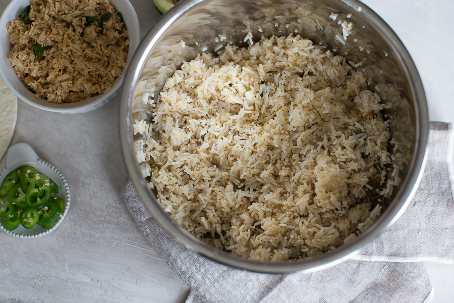 Overhead shot of cilantro lime rice in the Instant Pot with side of jalapenos and shredded chicken