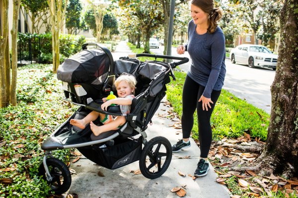 mom pushing two kids in double stroller