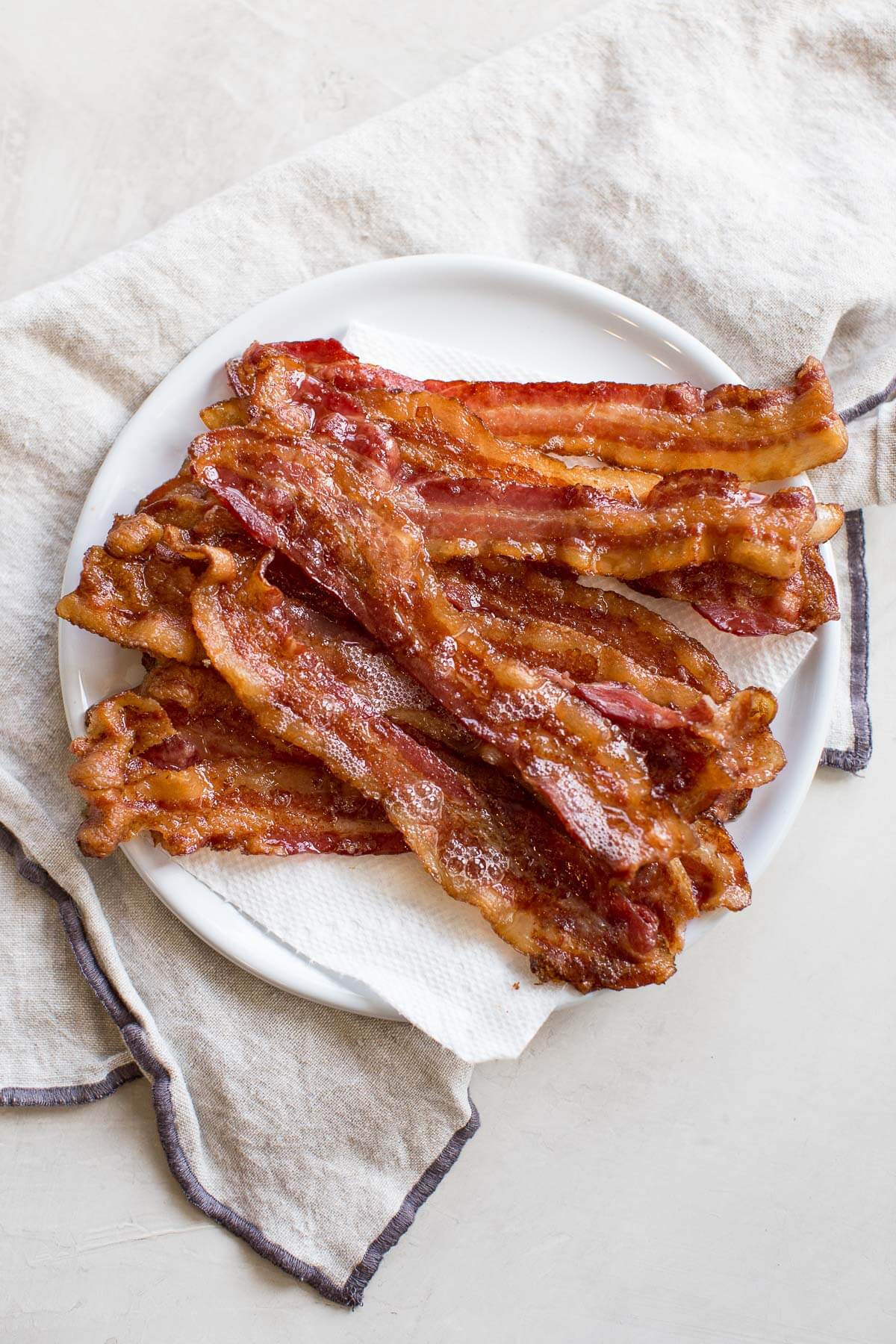 plate of bacon on paper towels after cooking bacon in the oven