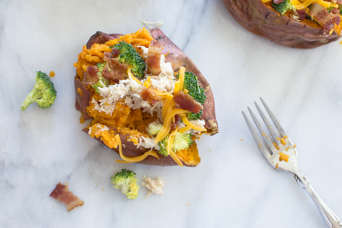overhead shot of sweet potato stuffed with cracked chicken, broccoli and sprinkled with cheese