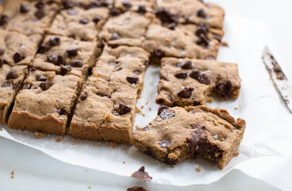 Side shot of almond butter blondie bar with a gooey and chocolatey center