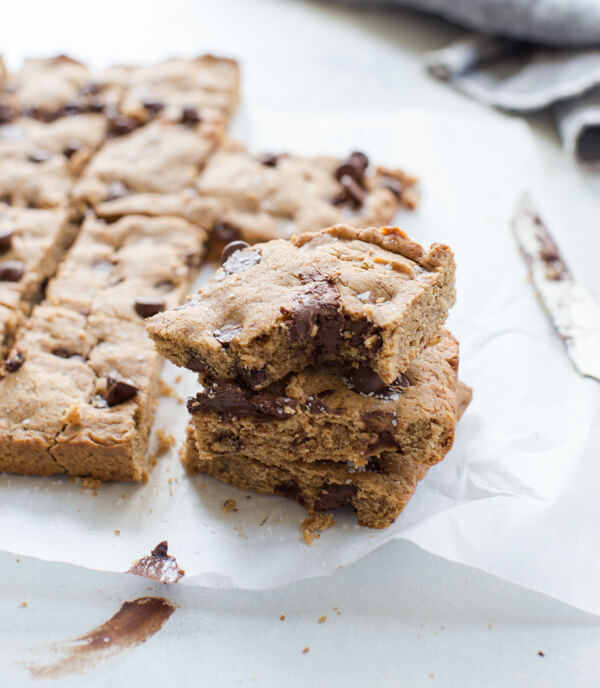 Side shot of a bitten almond butter blondie with melted chocolate in the center