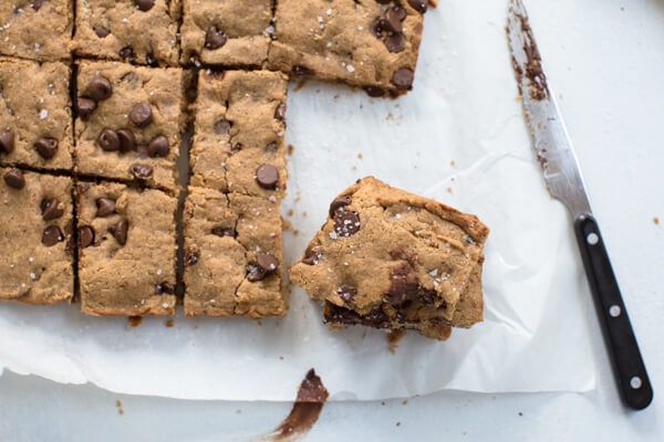 Overhead shot of two stacked almond butter blondies sprinkled with sea salt 