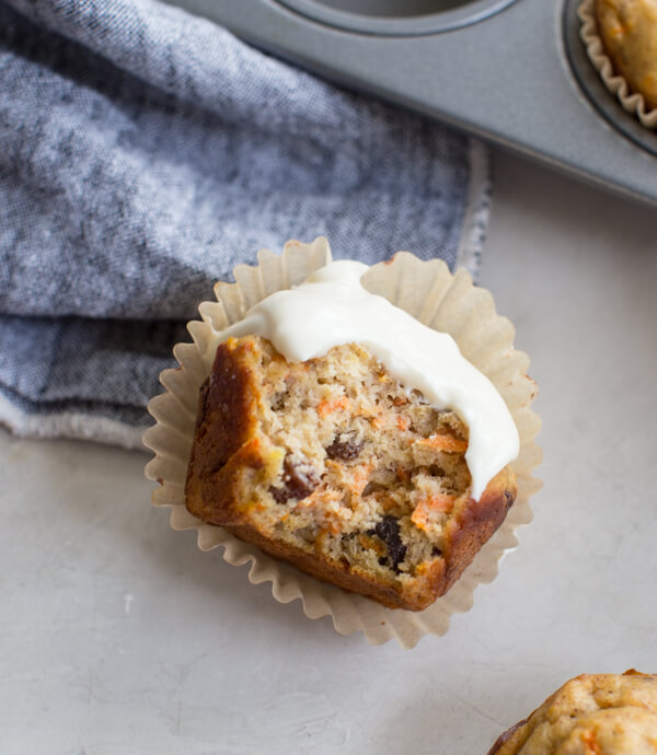 overhead shot of bitten carrot cake muffin with Greek yogurt frosting 