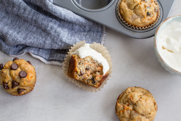 overhead shot of bitten gluten free carrot cake muffin with Greek yogurt frosting 