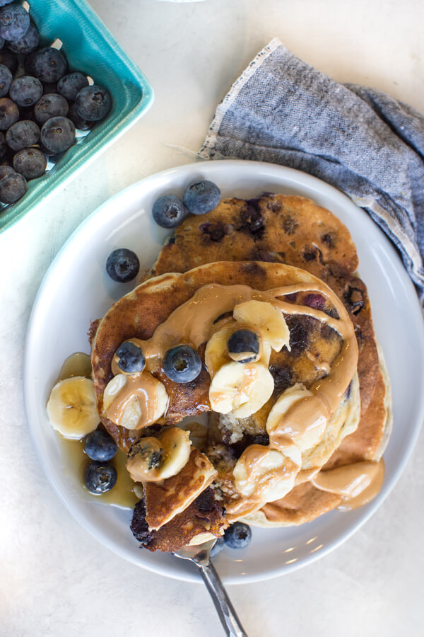 healthy blueberry pancakes with cashew butter and bananas