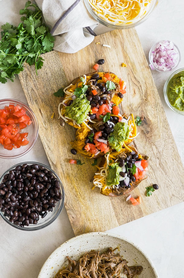 This Slow Cooker Carne Asada recipe is so easy to make with an authentic carne aside marinade stuffed into a microwaved sweet potato. Genius! 