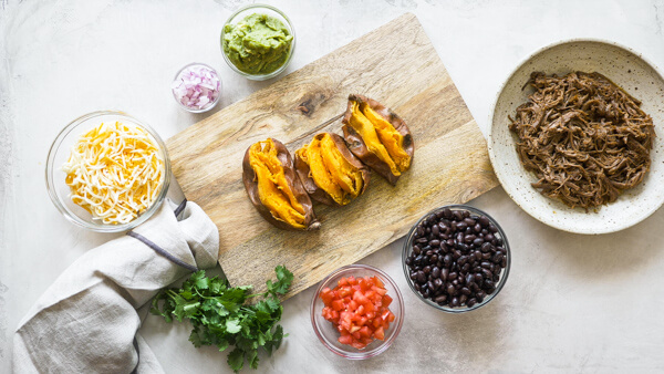 This Slow Cooker Carne Asada recipe is so easy to make with an authentic carne aside marinade stuffed into a microwaved sweet potato. Genius! 