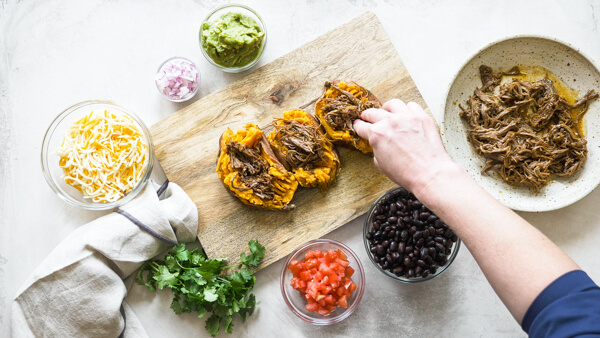 This Slow Cooker Carne Asada recipe is so easy to make with an authentic carne aside marinade stuffed into a microwaved sweet potato. Genius! 
