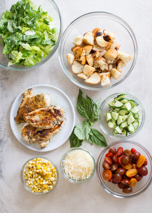 "End of Summer" Chicken Panzanella Salad recipe made with fresh tomatoes, cucumbers, chunks of toasty garlic bread, grilled corn, fresh basil, avocado, parmesan cheese. It's packed with perfectly seasoned grilled chicken for satiating protein and smothered in a thick balsamic vinegar. YUM!