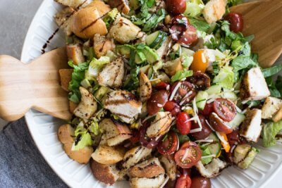 "End of Summer" Chicken Panzanella Salad recipe made with fresh tomatoes, cucumbers, chunks of toasty garlic bread, grilled corn, fresh basil, parmesan cheese. It's packed with perfectly seasoned grilled chicken for satiating protein and smothered in a thick balsamic vinegar. YUM!