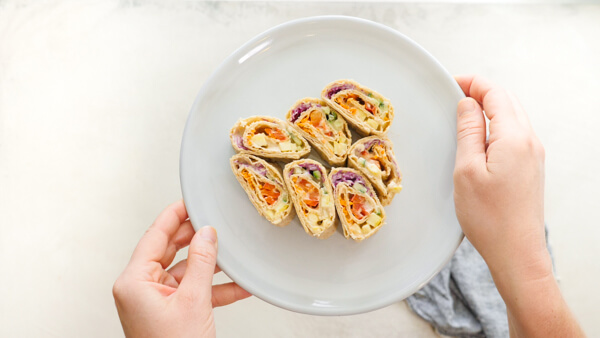 Easy pinwheel recipe for kids = Rainbow Veggie Pinwheels. A veggie loaded kid friendly lunch box recipe made with white bean hummus that encourages them to eat the rainbow. #pinwheels #veggie #rainbow #kidfriendly #lunchboxideas #healthykidrecipes