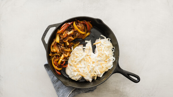 Chicken Fajita Casserole -- easy weeknight recipe with fajita veggies, black beans, sour cream and cheese on chicken breasts & baked in a cast iron skillet.