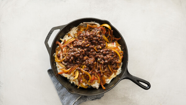 Chicken Fajita Casserole -- easy weeknight recipe with fajita veggies, black beans, sour cream and cheese on chicken breasts & baked in a cast iron skillet.